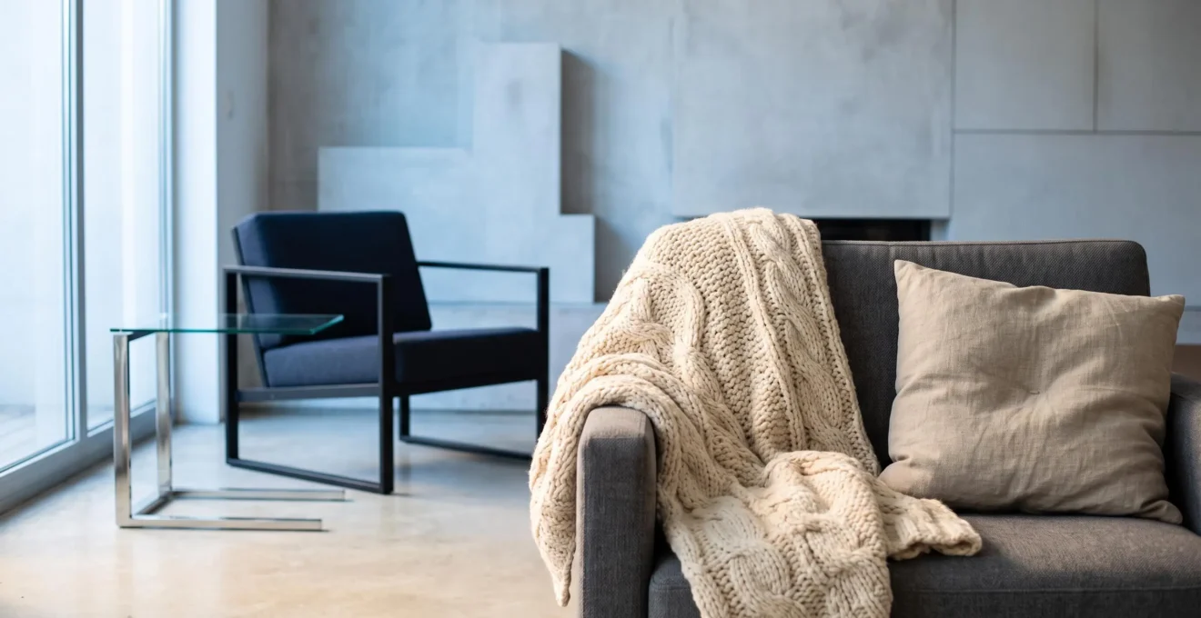 Contraste entre un salon de diseño frio y aséptico y un rincón cálido creado con textiles naturales